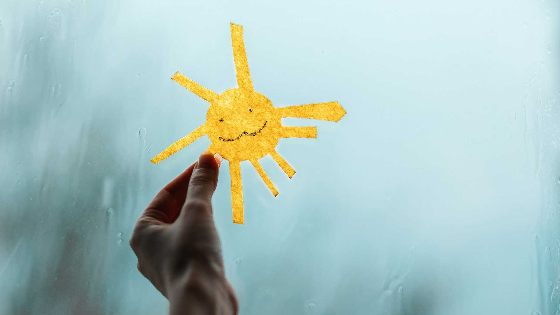 En hånd som holder en illustrert sol