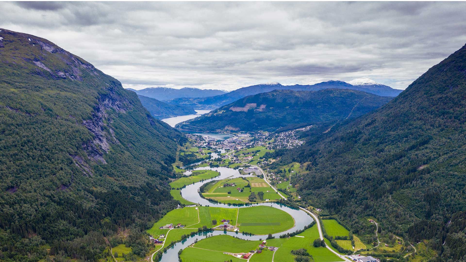 Fjord omgitt av bratte fjellsider i et dalføre.