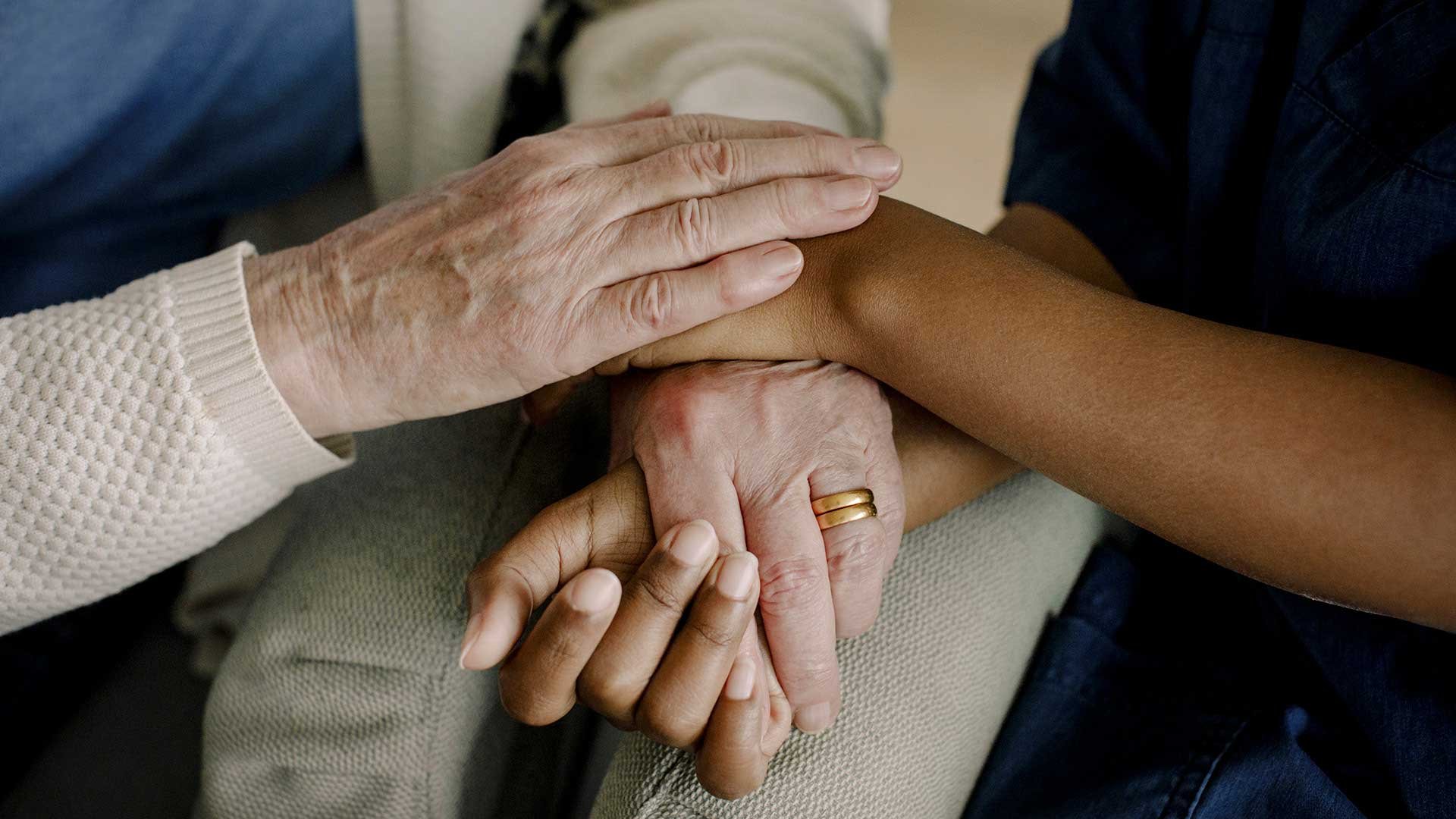 Två personer håller varandras händer med värme.